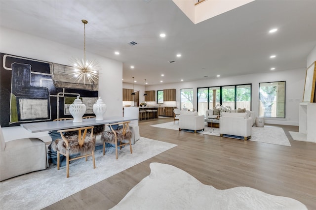 dining area with recessed lighting, light wood-style floors, visible vents, and an inviting chandelier