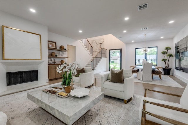 living area with stairs, recessed lighting, visible vents, and a fireplace
