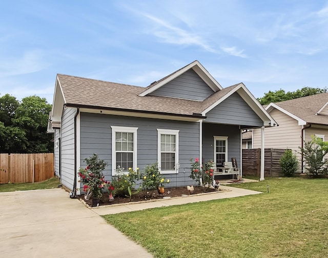 4713 Garrison Ave, Dallas, TX 75216 - view of front of property with fence, a shingled roof, a porch, and a front lawn