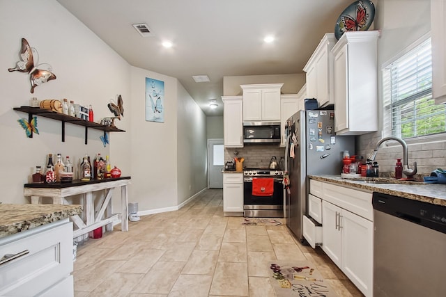 4713 Garrison Ave, Dallas, TX 75216 - kitchen featuring visible vents, white cabinets, a sink, appliances with stainless steel finishes, and backsplash
