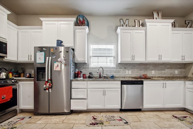 4713 Garrison Ave, Dallas, TX 75216 - kitchen with tasteful backsplash, a sink, light stone counters, white cabinets, and stainless steel appliances