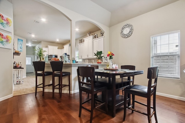 4713 Garrison Ave, Dallas, TX 75216 - dining space featuring visible vents, arched walkways, baseboards, and dark wood-style floors