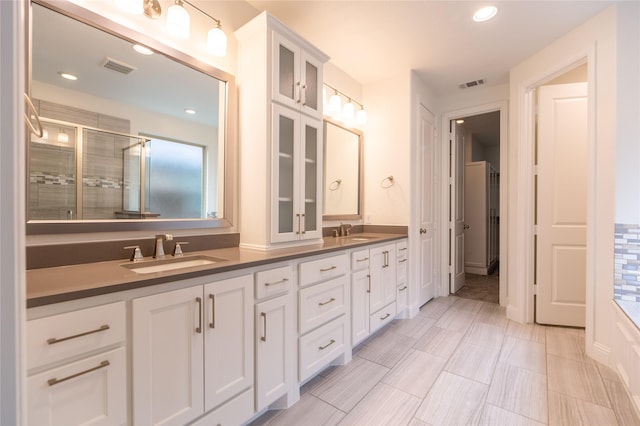 5521 Riverside Ln, Mckinney, TX 75070 - bathroom with double vanity, visible vents, a sink, and a stall shower