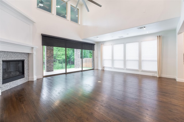 5521 Riverside Ln, Mckinney, TX 75070 - unfurnished living room featuring ceiling fan, visible vents, a tiled fireplace, wood finished floors, and baseboards