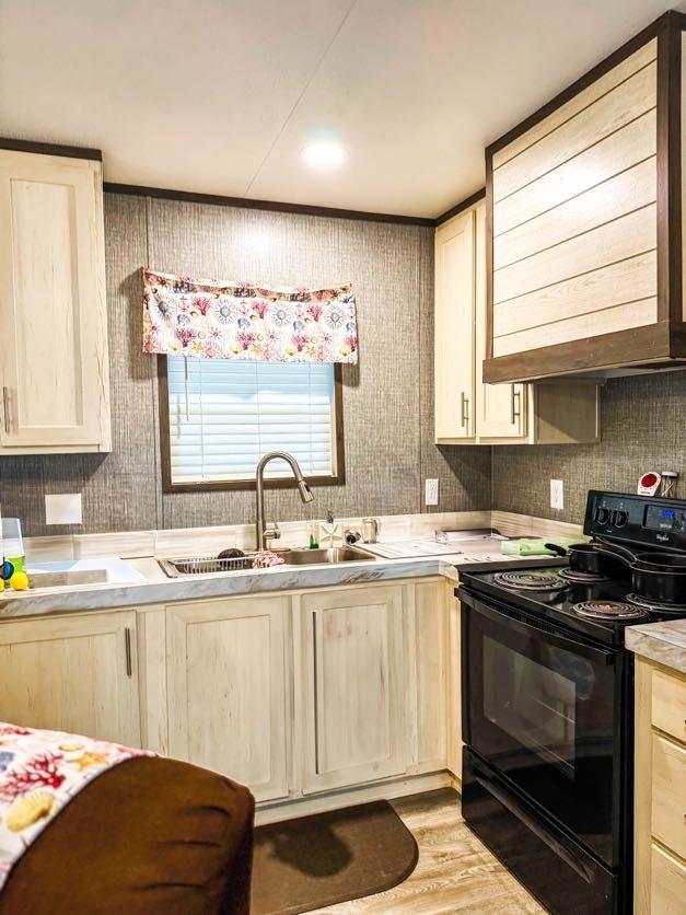 TBD County Road 891, Jewett, TX 75846 - kitchen with a sink, light wood finished floors, light brown cabinets, light countertops, and black electric range