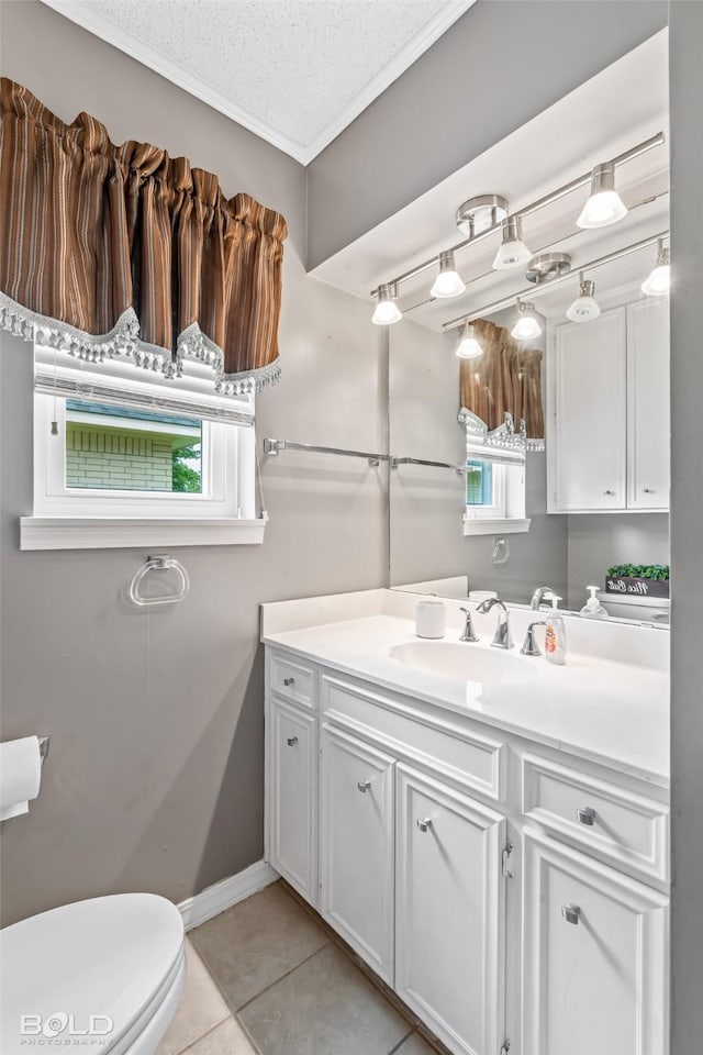 bathroom featuring crown molding, vanity, toilet, tile patterned floors, and baseboards