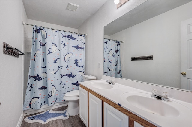 full bath featuring toilet, visible vents, a sink, and wood finished floors