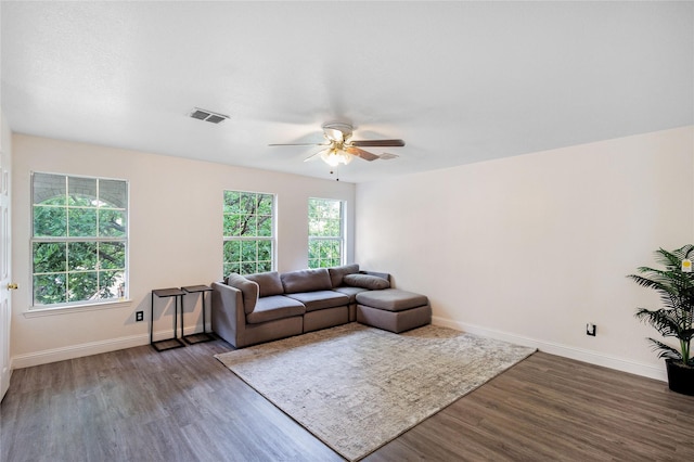 living area featuring a ceiling fan, baseboards, visible vents, and wood finished floors