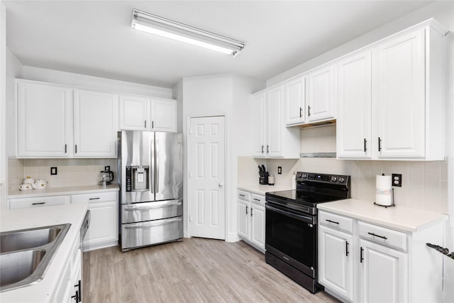 kitchen with stainless steel fridge, backsplash, range with electric cooktop, and white cabinetry