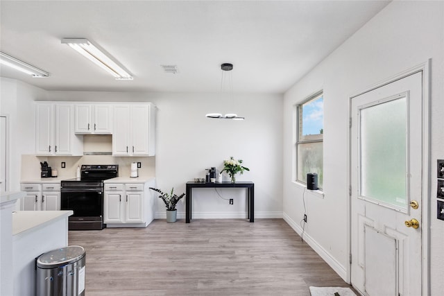 kitchen with light countertops, white cabinetry, stainless steel electric stove, and visible vents