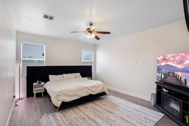 bedroom featuring visible vents, baseboards, and wood finished floors