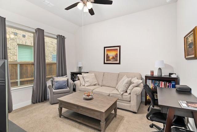 living room with a ceiling fan, light colored carpet, visible vents, vaulted ceiling, and baseboards