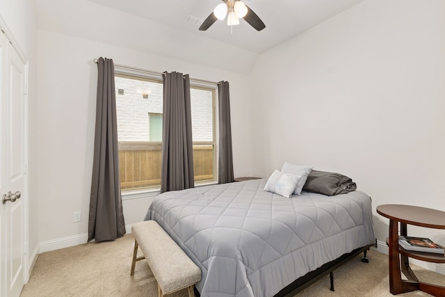 bedroom featuring baseboards, visible vents, vaulted ceiling, and light colored carpet