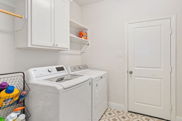 clothes washing area featuring washer and dryer, baseboards, light floors, and cabinet space