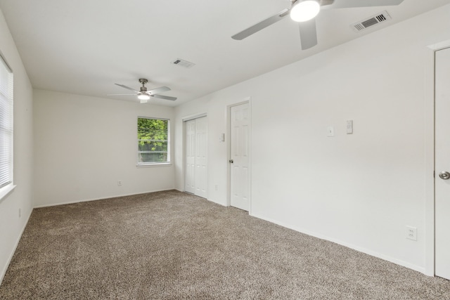spare room featuring visible vents, baseboards, ceiling fan, and carpet floors
