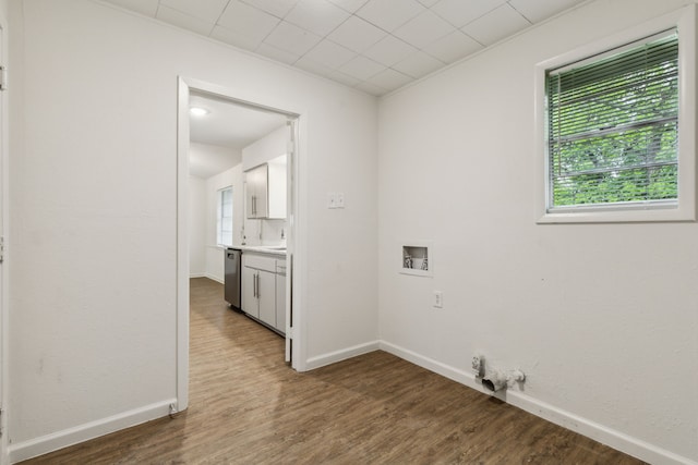 laundry area with baseboards, wood finished floors, and hookup for a washing machine