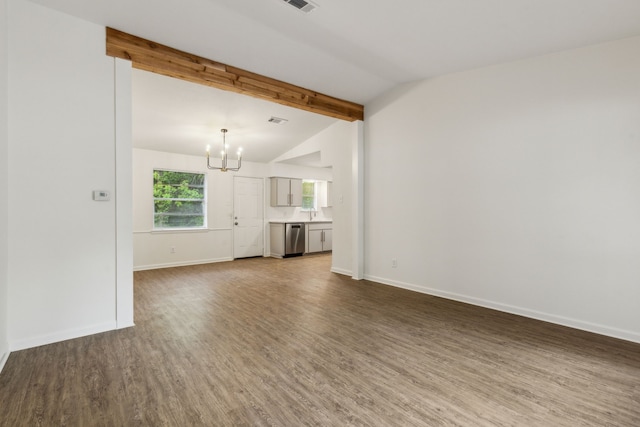 unfurnished living room featuring vaulted ceiling with beams, baseboards, a notable chandelier, and wood finished floors