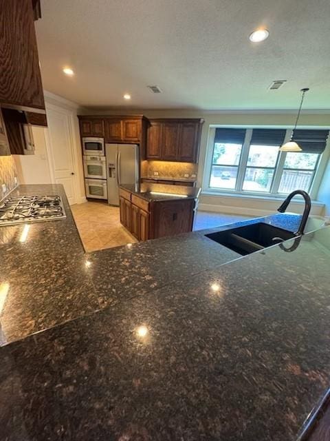 2823 Millington Dr, Highland Village, TX 75077 - kitchen featuring appliances with stainless steel finishes, a sink, a center island, healthy amount of natural light, and recessed lighting
