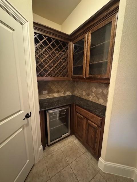 2823 Millington Dr, Highland Village, TX 75077 - wine cellar with wine cooler, light tile patterned flooring, and a dry bar