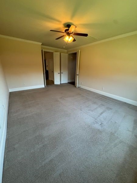 2823 Millington Dr, Highland Village, TX 75077 - unfurnished bedroom with crown molding, baseboards, ceiling fan, and carpet flooring