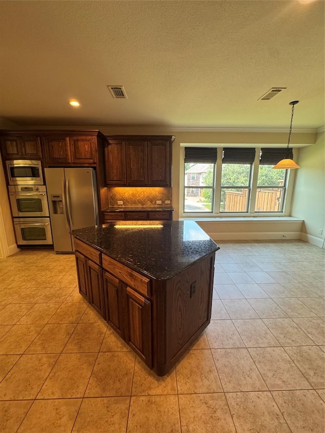 2823 Millington Dr, Highland Village, TX 75077 - kitchen with appliances with stainless steel finishes, ornamental molding, dark stone countertops, backsplash, and light tile patterned flooring