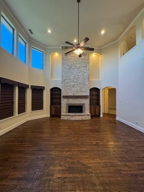 2823 Millington Dr, Highland Village, TX 75077 - unfurnished living room with ceiling fan, crown molding, a large fireplace, arched walkways, and baseboards