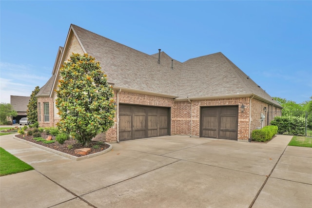 602 Limmerhill Dr, Rockwall, TX 75087 - view of home's exterior featuring driveway, brick siding, fence, an attached garage, and a shingled roof