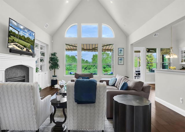 602 Limmerhill Dr, Rockwall, TX 75087 - living area with visible vents, a fireplace, dark wood-style floors, high vaulted ceiling, and built in shelves