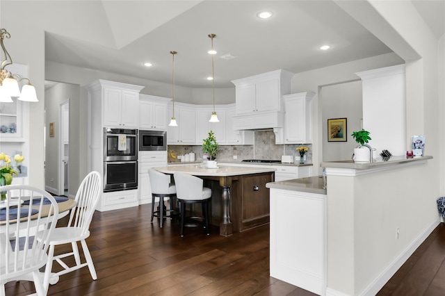 602 Limmerhill Dr, Rockwall, TX 75087 - kitchen featuring dark wood-type flooring, appliances with stainless steel finishes, white cabinets, and a kitchen breakfast bar