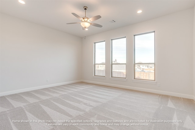 spare room featuring visible vents, baseboards, ceiling fan, and light colored carpet
