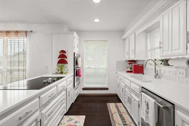 kitchen with light countertops, white cabinetry, appliances with stainless steel finishes, and a sink