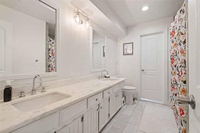 bathroom featuring a sink, tile patterned flooring, toilet, and double vanity