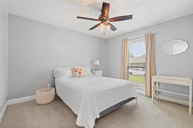 bedroom featuring a textured ceiling, ceiling fan, and carpet
