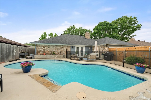 view of swimming pool featuring a grill, a patio, a fenced backyard, french doors, and a fenced in pool