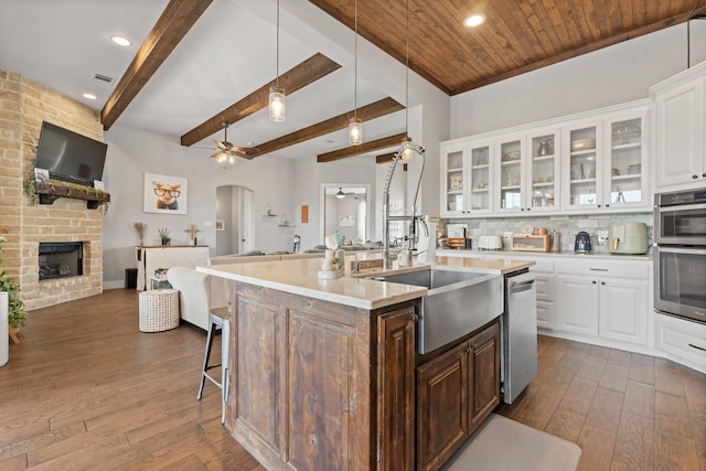 kitchen featuring open floor plan, a sink, ceiling fan, and dark wood-style floors