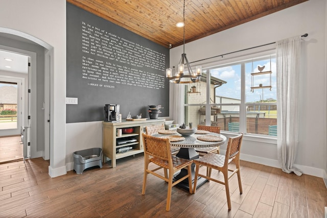 dining room with a healthy amount of sunlight, wood ceiling, baseboards, and wood finished floors