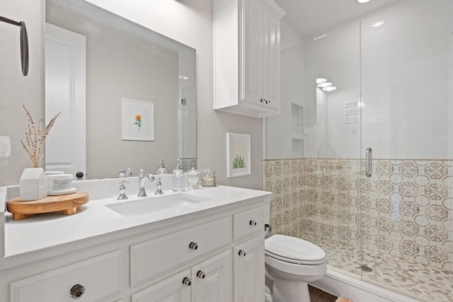 bathroom featuring vanity, a stall shower, and toilet