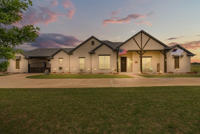view of front of home with curved driveway and a yard