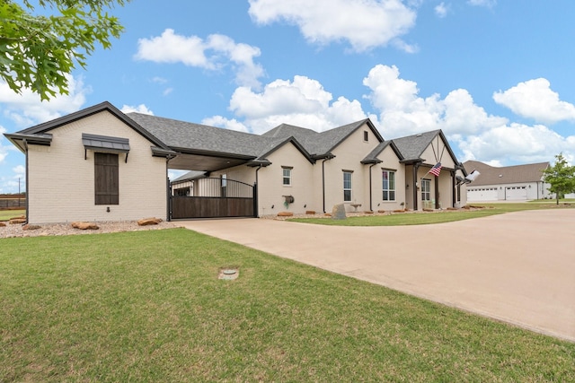 view of front of house with concrete driveway, brick siding, a gate, and a front lawn