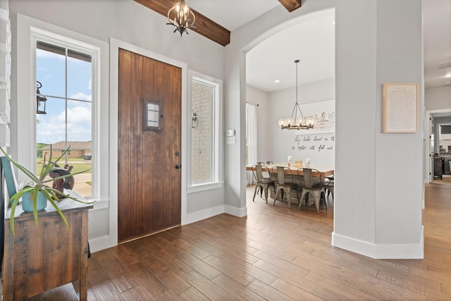 entryway featuring an inviting chandelier, baseboards, plenty of natural light, and wood finished floors