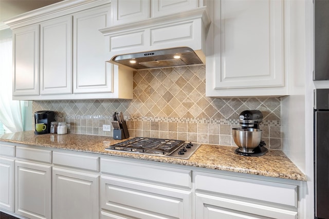 kitchen featuring stainless steel gas cooktop, white cabinetry, and tasteful backsplash