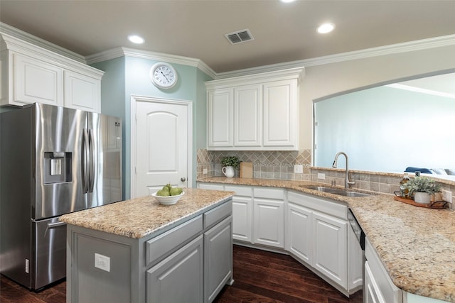 kitchen featuring stainless steel refrigerator with ice dispenser, ornamental molding, a sink, and white cabinetry