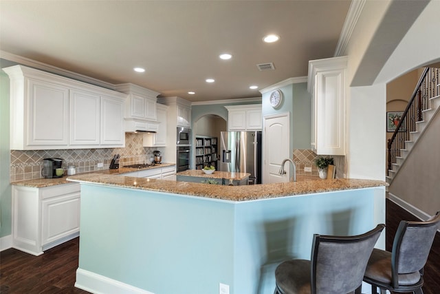kitchen with crown molding, arched walkways, tasteful backsplash, dark wood-style floors, and stainless steel appliances
