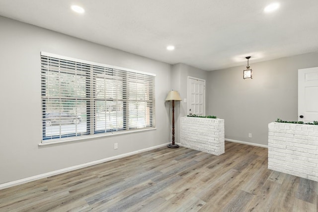 unfurnished living room with baseboards, recessed lighting, and wood finished floors