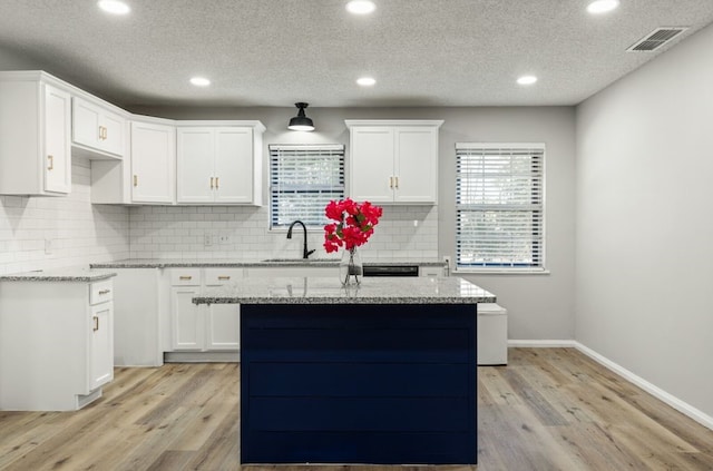 kitchen with recessed lighting, light stone countertops, and light wood-type flooring