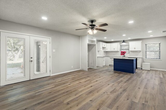 kitchen with white cabinetry, plenty of natural light, french doors, and a center island