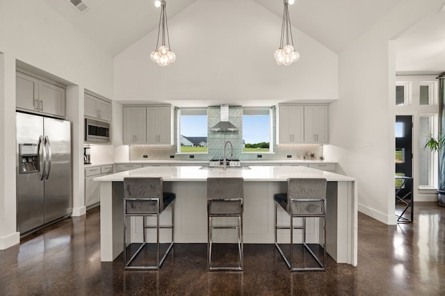 kitchen with light countertops, high vaulted ceiling, wall chimney exhaust hood, stainless steel appliances, and decorative backsplash