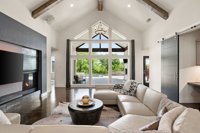 living area featuring visible vents, beam ceiling, baseboards, high vaulted ceiling, and a barn door