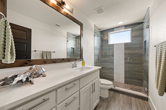 full bathroom with vanity, a stall shower, and visible vents