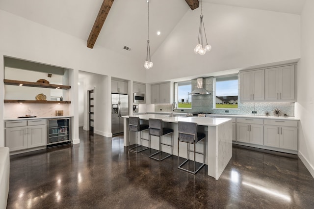 kitchen featuring visible vents, appliances with stainless steel finishes, high vaulted ceiling, wine cooler, and wall chimney exhaust hood